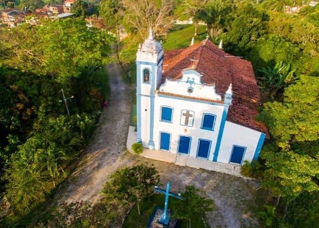 Igreja de Santo Amaro do Catu, branca e azul, cercada por vegetação