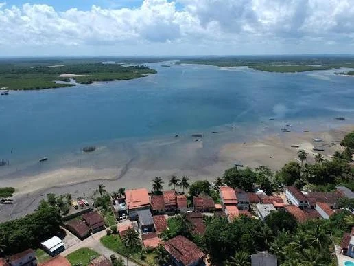 Vista aérea de Jiribatuba com casas, praia, águas rasas e manguezais